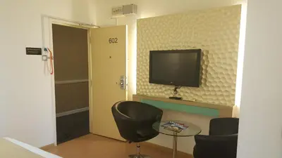 a room with a tv and a table and chairs at Holiday Place Kuala Lumpur in Kuala Lumpur