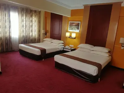 a hotel room with two beds and a red carpet at Palace Hotel in Kuala Lumpur