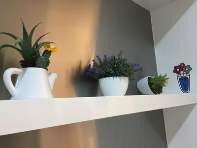 a shelf with three vases and plants on it at Homely Apartment with Great Facilities and Free Parking in Kuala Lumpur