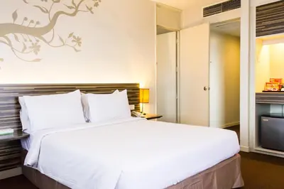 a bedroom with a large white bed and a tv at The 5 Elements Hotel Chinatown Kuala Lumpur in Kuala Lumpur