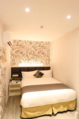 a bedroom with a large white bed with a wall at M&M Hotel in Kuala Lumpur
