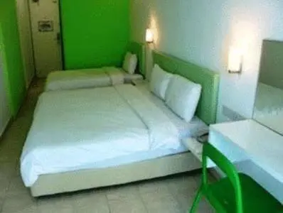 a green bedroom with a white bed and a desk at YY38 Hotel in Kuala Lumpur