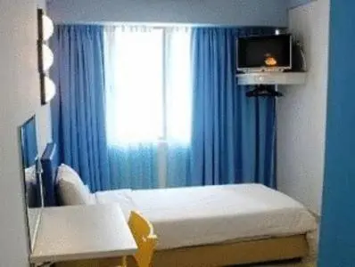 a bedroom with a bed and a window with blue curtains at YY38 Hotel in Kuala Lumpur