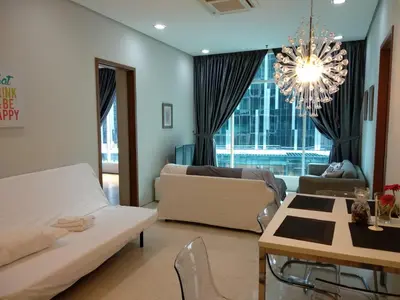 a living room with a couch and a table and a chandelier at Soho Suites KLCC by LX Suites in Kuala Lumpur