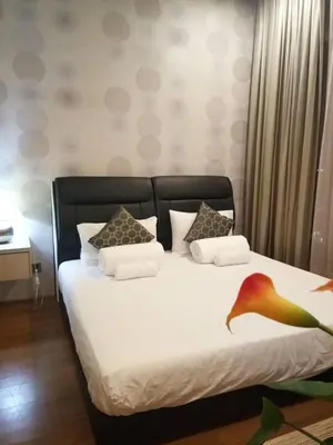a bedroom with a bed with white sheets and pillows at Soho Suites KLCC by LX Suites in Kuala Lumpur