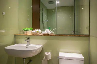 a bathroom with a sink and a toilet and a mirror at Soho Suites KLCC by LX Suites in Kuala Lumpur