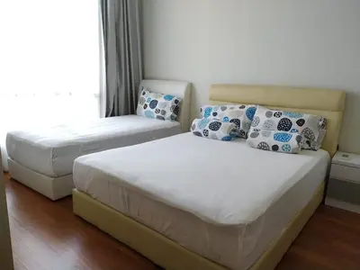 a bedroom with two beds and a window at Soho Suites KLCC by LX Suites in Kuala Lumpur