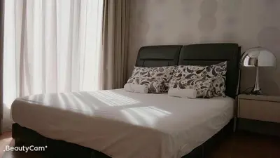 a bedroom with a large bed with white sheets and pillows at Soho Suites KLCC by LX Suites in Kuala Lumpur