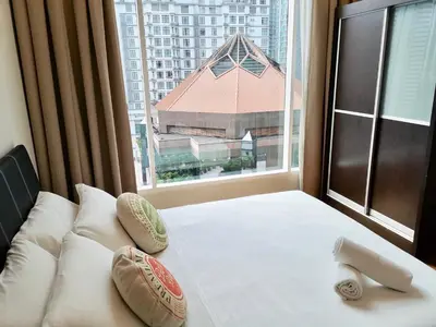 a bed in a room with a large window at Soho Suites Klcc By Pnut KLCC VIEW in Kuala Lumpur