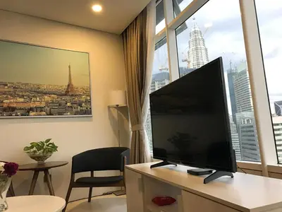 a living room with a large flat screen tv in front of a window at VORTEX SUITES KLCC by PNUT With NETFLIX in Kuala Lumpur