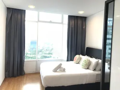 a bedroom with a white bed with a large window at VORTEX SUITES KLCC by PNUT With NETFLIX in Kuala Lumpur
