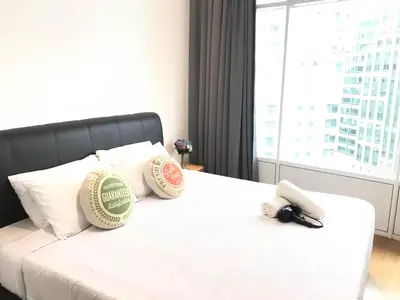 a bed with two baseball pillows on it with a window at VORTEX SUITES KLCC by PNUT With NETFLIX in Kuala Lumpur