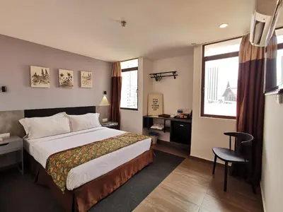 a hotel room with a bed and a desk and window at Leo Palace Hotel New Wing, WTC Kuala Lumpur in Kuala Lumpur
