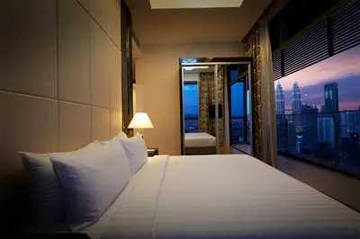 a bedroom with a bed with a view of a city at Dorsett Residences Bukit Bintang @Dorsett Kuala Lumpur in Kuala Lumpur