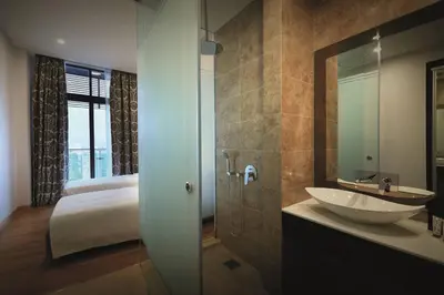 a bathroom with a sink and a bed and a mirror at Dorsett Residences Bukit Bintang @Dorsett Kuala Lumpur in Kuala Lumpur