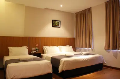 a hotel room with two beds and a window at Ahyu Hotel in Kuala Lumpur