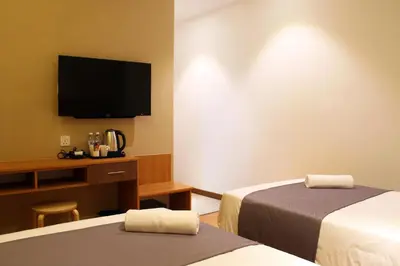 a hotel room with two beds and a flat screen tv at Ahyu Hotel in Kuala Lumpur