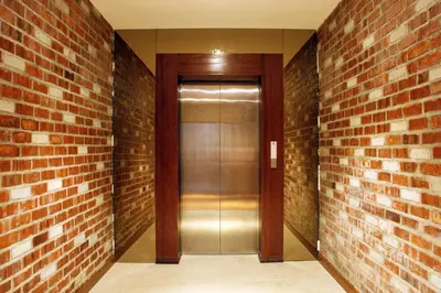 a walkway with a glass door in a brick wall at Ahyu Hotel in Kuala Lumpur