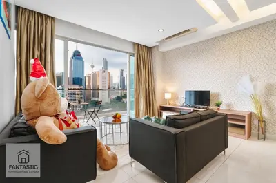 a teddy bear sitting on a couch in a living room at Regalia Residence @ KLCC View Sky Pool by MC in Kuala Lumpur