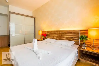 a bedroom with a large bed with white sheets at Regalia Residence @ KLCC View Sky Pool by MC in Kuala Lumpur