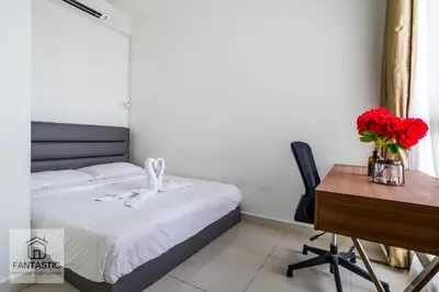 a bedroom with a bed and a desk and a table and red flowers at Regalia Residence @ KLCC View Sky Pool by MC in Kuala Lumpur