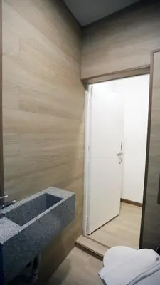 a bathroom with a sink and a large door at Vivids Hotel in Kuala Lumpur