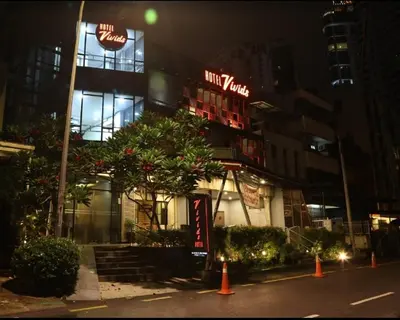 a restaurant with neon signs on the side of a building at Vivids Hotel in Kuala Lumpur