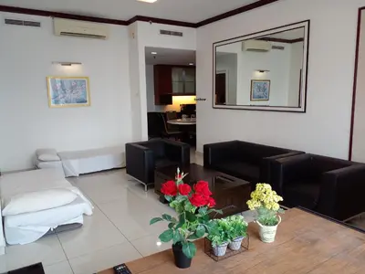 a living room with a couch and a table with flowers at Sunbow Suites @ Times Square Kuala Lumpur in Kuala Lumpur