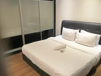 a bedroom with a large white bed with a mirror at Taragon Putrie Bintang suites in Kuala Lumpur