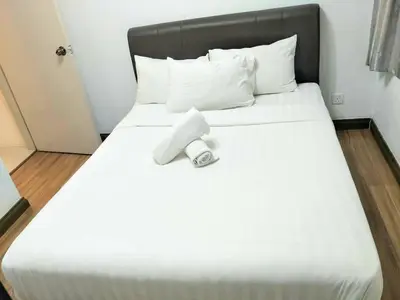 a large white bed with a remote control on it at Taragon Putrie Bintang suites in Kuala Lumpur