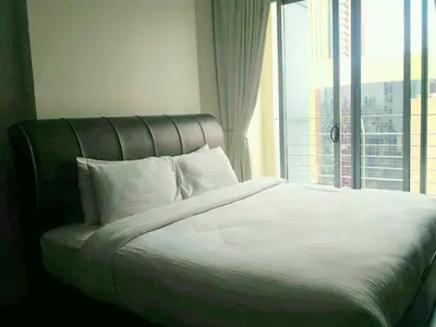a bed in a room with a large window at Taragon Putrie Bintang suites in Kuala Lumpur