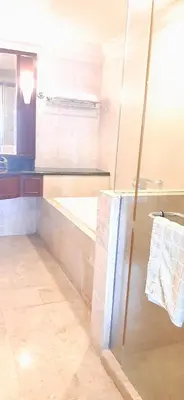 a bathroom with a glass shower and a sink at Genius Service Suites at time square kl in Kuala Lumpur