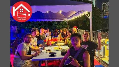 a group of people sitting at a table under a tent at Travelogue Guest House in Kuala Lumpur