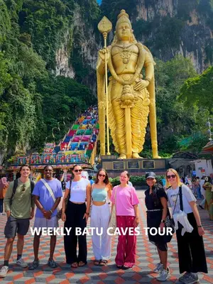 a group of people standing in front of a large statue at Travelogue Guest House in Kuala Lumpur