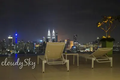 two chairs sitting on top of a building at night at Sentrio Pandan Kuala Lumpur in Kuala Lumpur