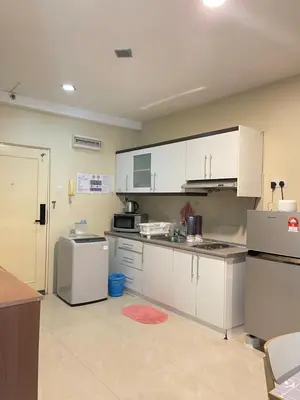 a kitchen with white cabinets and a refrigerator at Parkview Suite KLCC, Myhomey in Kuala Lumpur