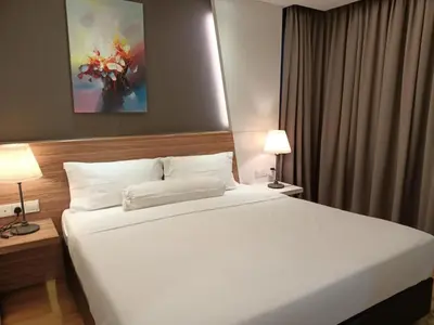 a bedroom with a large white bed and two lamps at Royal Suite in Kuala Lumpur