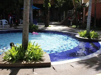 a pool with a palm tree and a person in it at FnF Suite @ Time Square in Kuala Lumpur