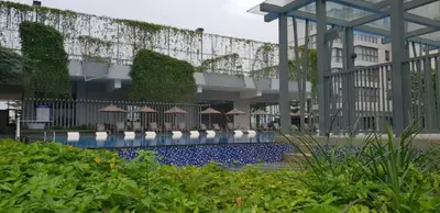 a swimming pool with umbrellas in front of a building at TRILLION SUITES by SLG in Kuala Lumpur