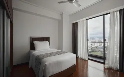a white bedroom with a bed and a large window at TRILLION SUITES by SLG in Kuala Lumpur