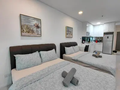 a living room with two beds and a kitchen at Inspired Homes @ Summer Suite in Kuala Lumpur