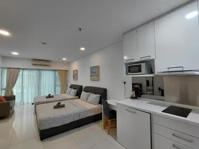 a kitchen and a living room with a bed in a room at Inspired Homes @ Summer Suite in Kuala Lumpur