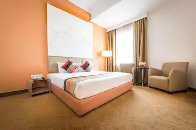 a hotel room with a large bed and a chair at Hotel Sentral Pudu @ City Centre / Bukit Bintang in Kuala Lumpur