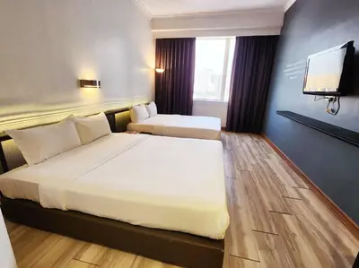 a hotel room with two beds and a flat screen tv at Hotel Sentral Pudu @ City Centre / Bukit Bintang in Kuala Lumpur