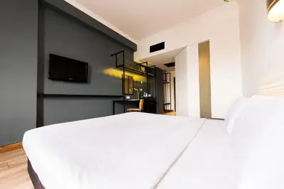 a bedroom with a white bed and a flat screen tv at Hotel Sentral Pudu @ City Centre / Bukit Bintang in Kuala Lumpur