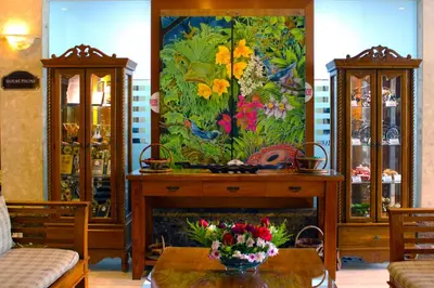 a living room with a fireplace and a painting of flowers at Hotel Maluri in Kuala Lumpur