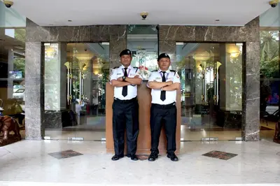two men in bow ties standing in front of a store at Hotel Maluri in Kuala Lumpur