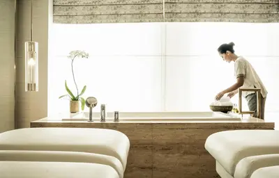 a man standing in a kitchen preparing food at Four Seasons Hotel Kuala Lumpur in Kuala Lumpur