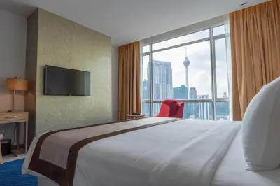 a hotel room with a large bed and a large window at Tamu Hotel & Suites Kuala Lumpur in Kuala Lumpur