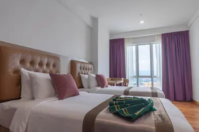 a hotel room with two beds and a large window at Tamu Hotel & Suites Kuala Lumpur in Kuala Lumpur